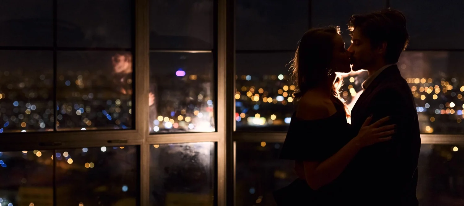 Adult couple sharing a romantic moment overlooking city lights